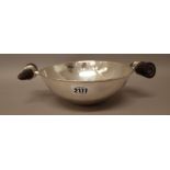 A foreign bowl of circular form, having a beaten finish, the handles mounted with tusks,