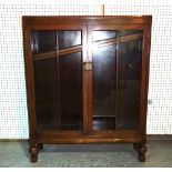 A 20th century oak two door bookcase on bulbous turned supports, 92cm wide x 116cm high, (a.f).