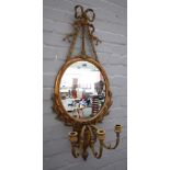 A 19th century gilt framed girandole wall mirror with ribbon tied crest above oval plate and triple