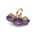 A gold, purple and blue synthetic corundum three stone ring,