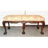 A George III style mahogany rectangular footstool on tapering ball and claw supports,