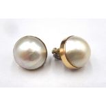 Two similar gold mounted mabe pearl earclips, the backs with hinged sprung clip fittings, (2).