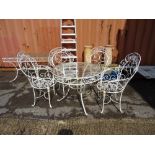 A 20th century white painted metal circular garden table with a matching set of four white metal