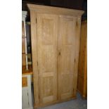 A 20th century pine double wardrobe with panel doors on plinth base, 108cm wide x 198cm high.