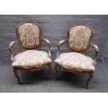 A pair of late 18th century French green painted open armchairs, with floral carved crest,