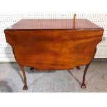 An early 20th century mahogany drop flap table with shaped top and stylized hoof feet,