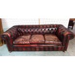 A 20th century mahogany framed Chesterfield sofa with red leatherette button back upholstery,