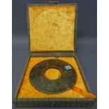 A Chinese jade bi disc, carved each side with archaistic scrolls, the stone of greyish green,