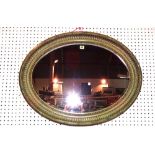 A 20th century gilt framed oval mirror, 65cm wide x 85cm high.