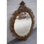 A 19th century floral cast ormolu oval mirror, with cartouche upper and lower frieze,