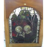A 19th century leaded stained glass panel depicting religious figures within a darker oak frame,
