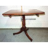A 19th century mahogany square tripod table with turned column and three outswept supports,