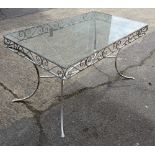 A 20th century white painted metal rectangular garden table with inset glass top on outswept
