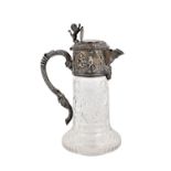 A silver mounted faceted glass claret jug, the mount decorated with cherubs,