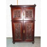 A Victorian mahogany side cabinet with foliate carved panel doors on bun supports,