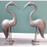 A pair of large Middle Eastern damascened metal storks, each bird standing looking straight ahead,