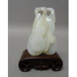 A Chinese white jade carving of gourds, 6cm.high, wood stand, (2).