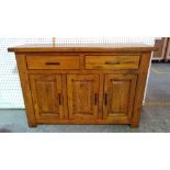 A 20th century hardwood sideboard with two short drawers over a three door cupboard base,