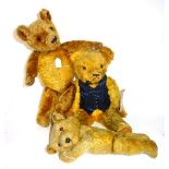 Three early 20th century teddy bears, possibly 'Merrythought', with golden fur and jointed limbs,