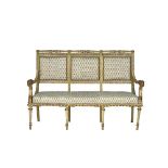 A French 18th century style parcel gilt cream painted open arm sofa, with eagle head finials,