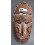 A carved tribal wall mask, Papua New Guinea, with inset shell eyes and painted decoration,
