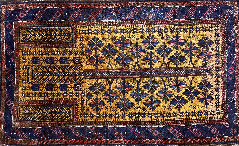 A Beluchistan prayer rug, the saffron mehrab with a flowering tree of life, plant spandrels,