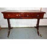 A Regency mahogany writing table with green leather inset top on reeded sabre supports,