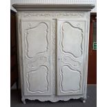 An 18th century and later white painted French armoire with a pair of shaped panel doors on scroll