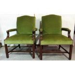 A pair of George III style mahogany open armchairs with green upholstery on square block supports,