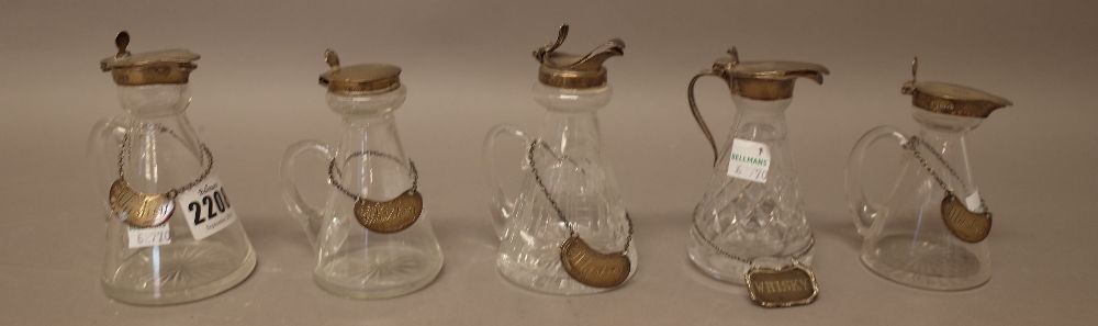 A collection of five silver mounted glass whisky noggins, in a variety of designs,