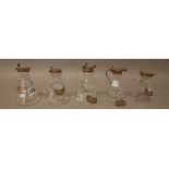 A collection of five silver mounted glass whisky noggins, in a variety of designs,