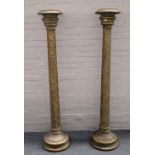 A pair of 18th century style parcel gilt green painted torcheres with scale carved column and
