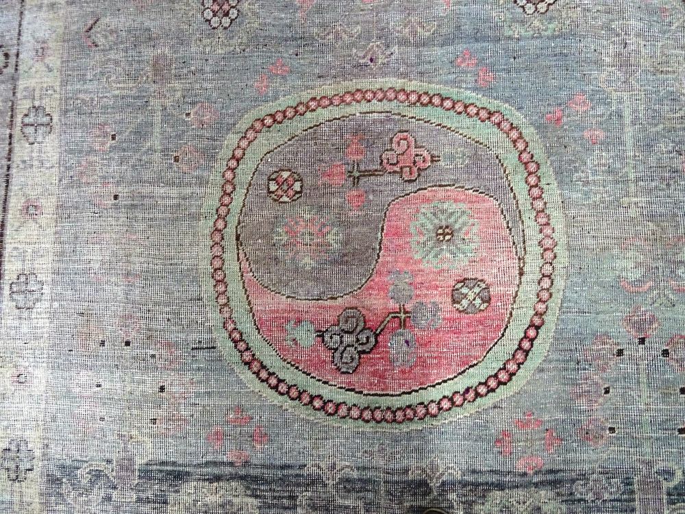 A Khotan carpet, ,the faded purple field with three bold roundels, - Image 3 of 7