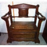 A mid-20th century oak hall bench, with lift top seat flanked by umbrella stand,