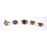 A gold and amethyst three stone ring, claw set with a row of oval cut amethysts, detailed 10 K,