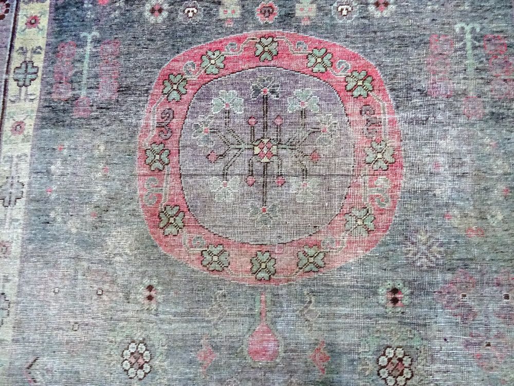 A Khotan carpet, ,the faded purple field with three bold roundels, - Image 4 of 7