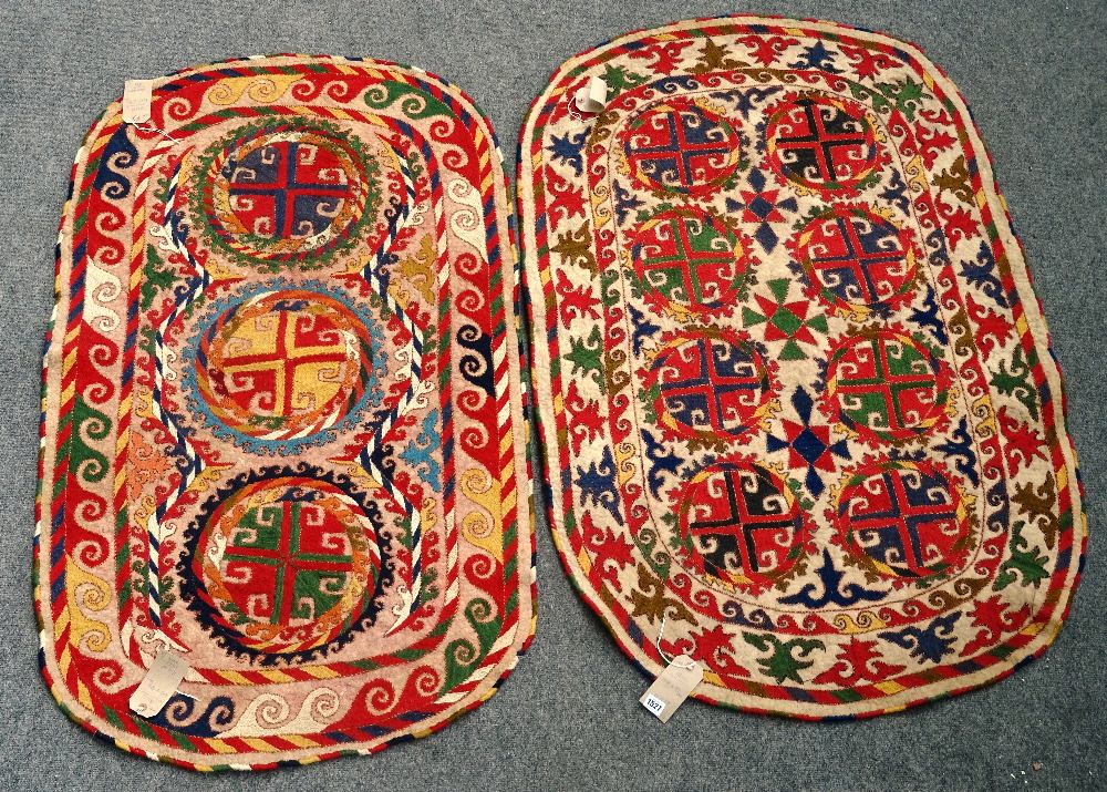 An Uzbek felt saddle cloth, the ivory field with two column of four cross roundels,