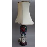 A Moorcroft style pottery table lamp of foliate Arts & Crafts design on a wooden plinth with shaped