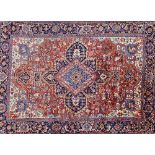 A Heriz carpet, Persian, the madder field with a bold central medallion, ivory spandrels,