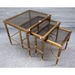 A nest of three 20th century lacquered brass and glass occasional tables on reeded supports,