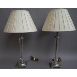 A pair of modern moulded glass and silver metal mounted table lamps with cream silk pleated shades,