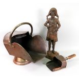 A copper helmet coal scuttle and scoop and a cast iron figural doorstop in the form of a town crier,