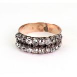 A two row diamond ring, each row mounted with ten old cut diamonds, in claw settings to plain band,