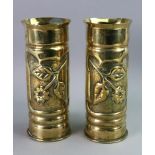 A pair of trench art brass cylindrical shell cartridges, each decorated with a flower,