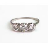 A diamond three stone ring, claw set with circular old cut diamonds, ring size N 1/2, 2.87g gross.