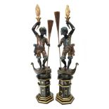 A pair of carved ebonised polychrome pai