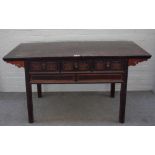 A late 19th century lacquered softwood three drawer side table on block supports,