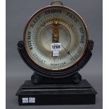 A Victorian style French brass cased barometer of circular form on a shaped wooden stand,