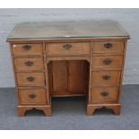 A late 19th century walnut kneehole writing desk with nine drawers about the knee cupboard on