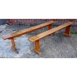 A pair of 19th century French fruitwood rectangular benches on silhouette trestle end supports,